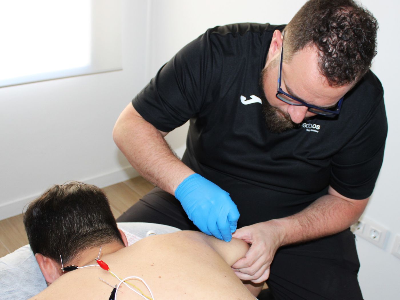 Fisioterapeuta aplicando una técnica de punción en la zona dorsal